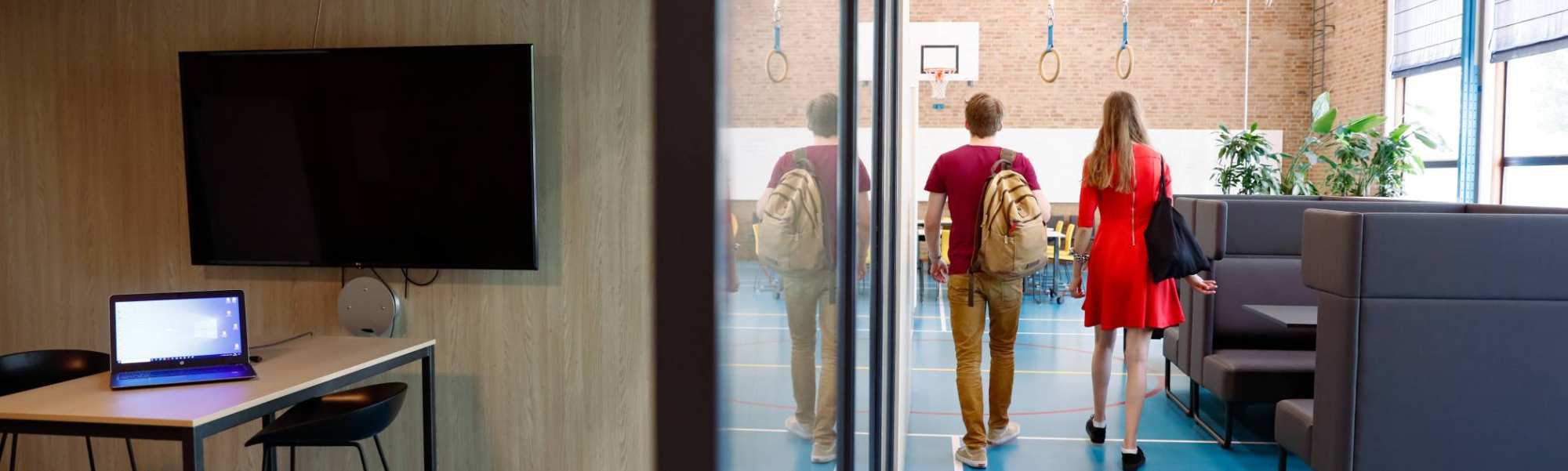 2 HBO master studenten lopen naar het leslokaal in de gymzaal op HAN campus
