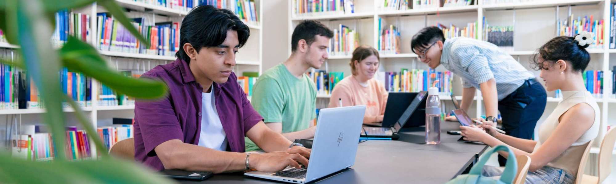 International students Diego, Tam, Nyugen, Noa and Andrei studying in the library at the Arnhem campus of HAN University of Applied Sciences.