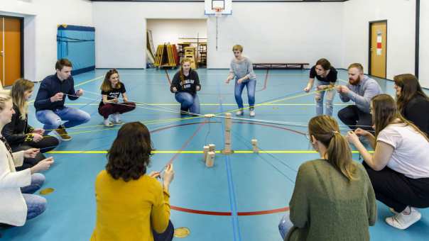 Een grote groep studenten Social Work is bezig met een spel tijdens het creatieve vak Sport & Spel.