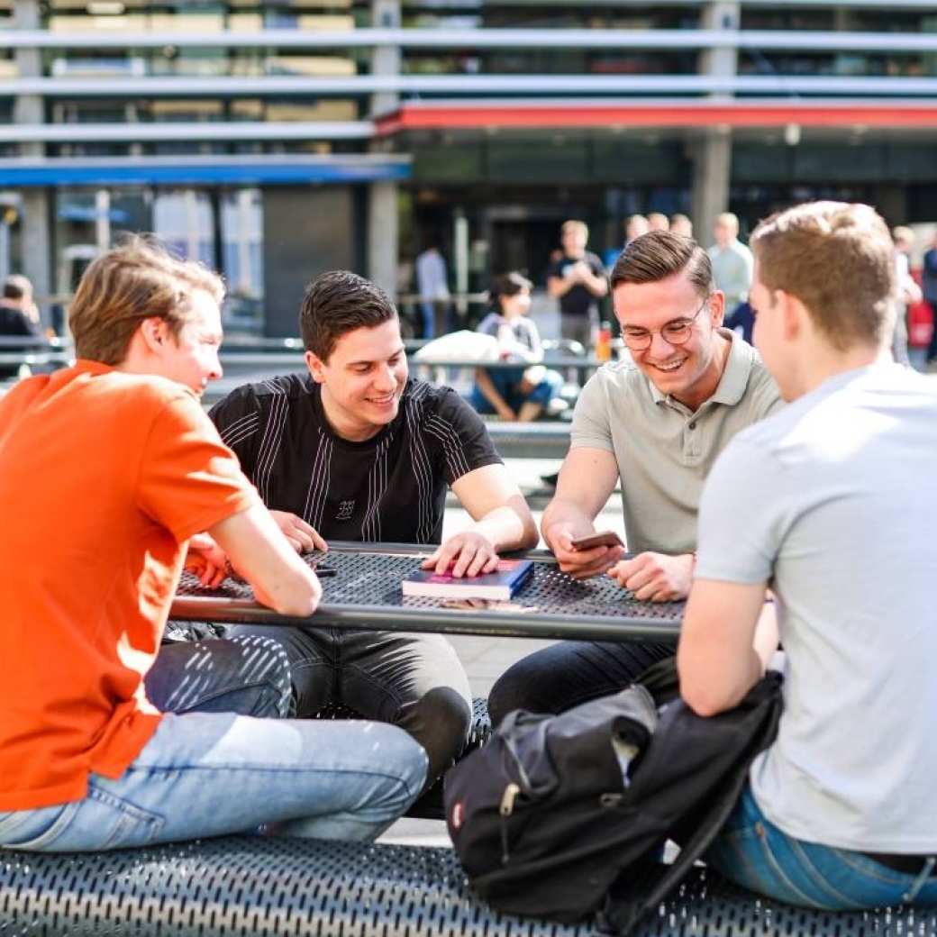 Logistics Management voltijd, foto 8383, studenten buiten aan tafel op het plein in Arnhem