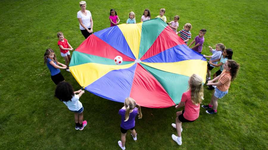 kinderen spelen een spel met een kleurrijke parachute