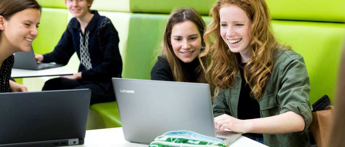 ALPO-studenten zitten allemaal lachend achter hun laptop te werken.