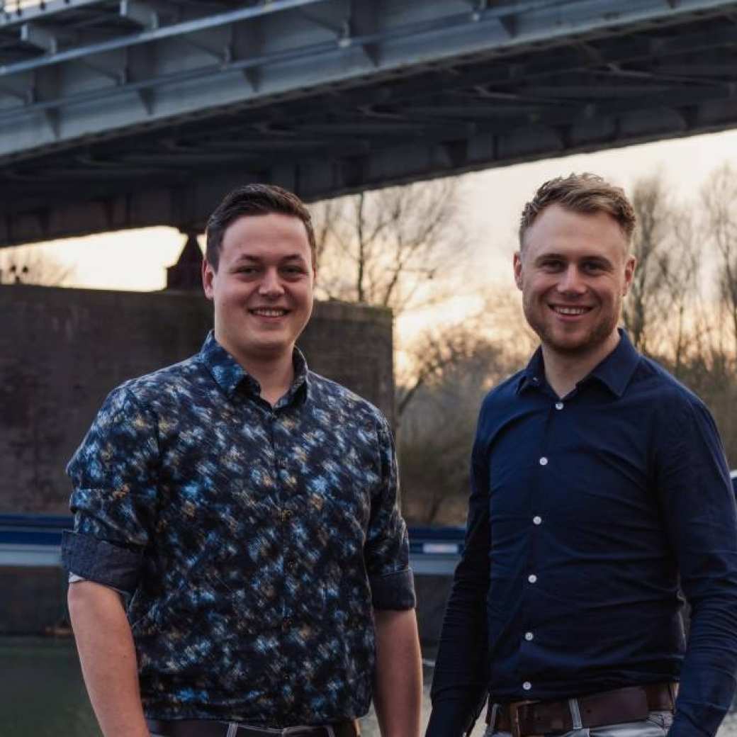 Tom Kreeftenberg en Gijs ten Elshof zijn alumni Technische Bedrijfskunde en zij poseren bij een brug