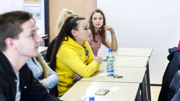 Een vrouwelijke student Social Work is aanwezig in een college op de K33 en kijkt aandachtig.