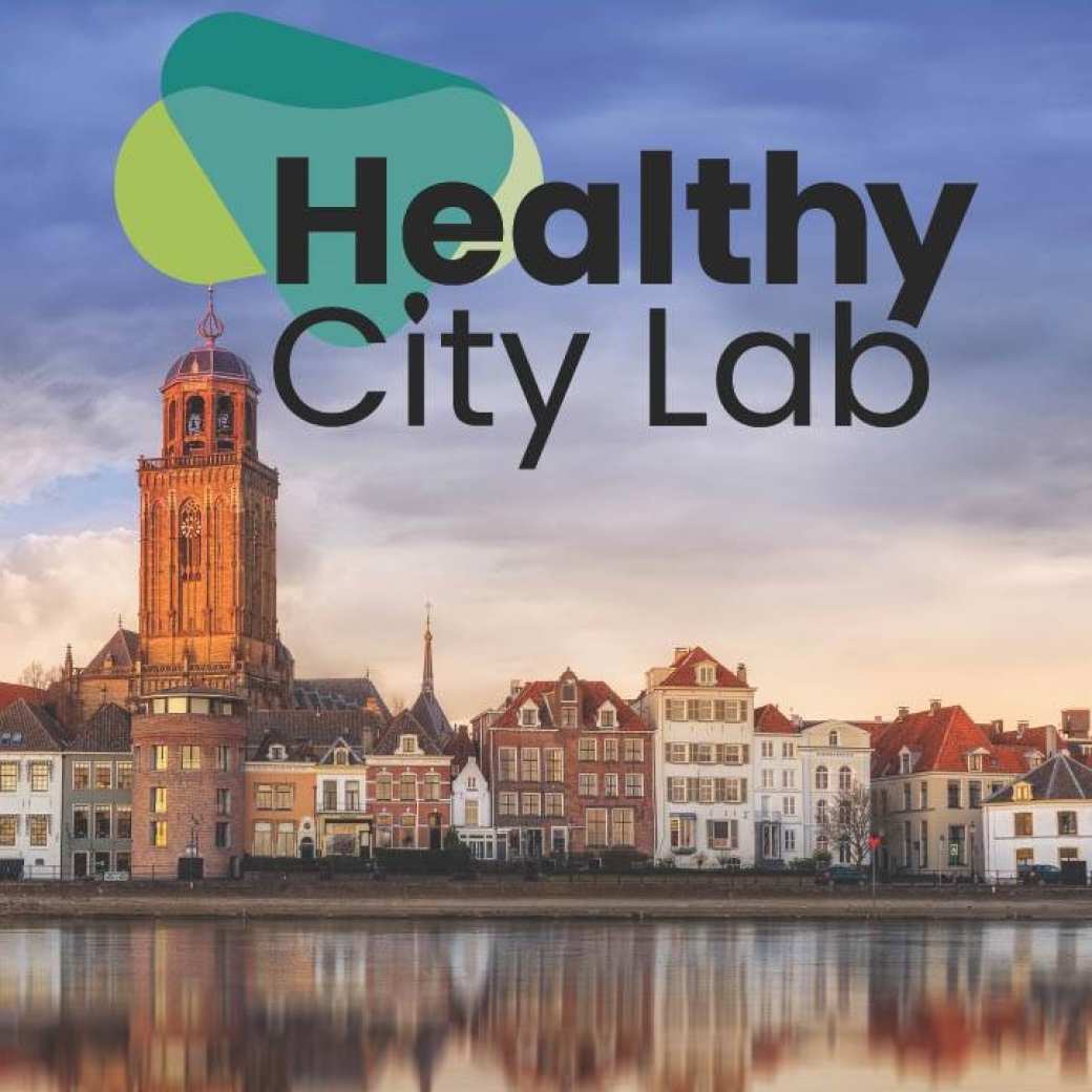 Afbeelding van de Ijsselkade in Deventer, met de tekst Healthy City Lab bovenaan in beeld en onderaan logo's van alle partners