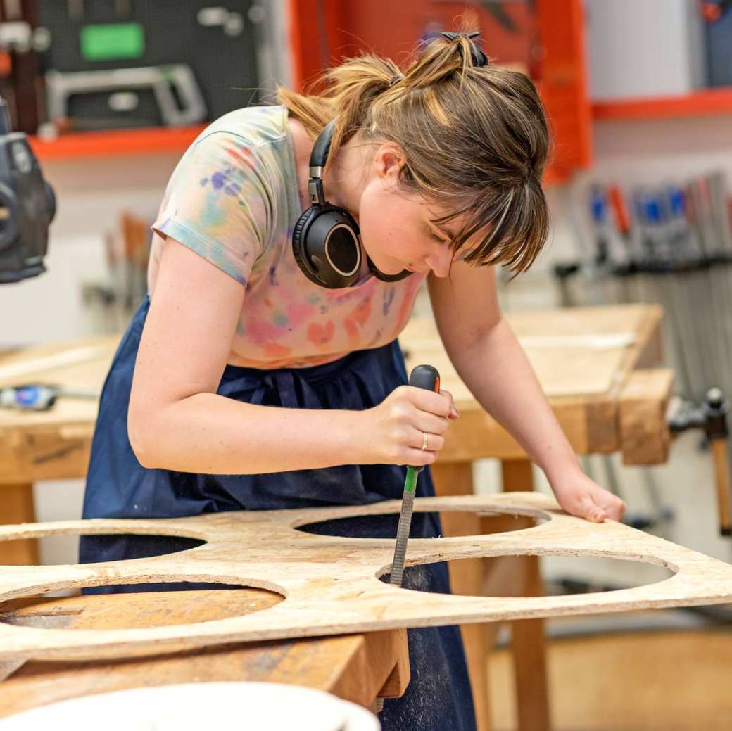 Meisje bewerkt hout in houtlokaal
