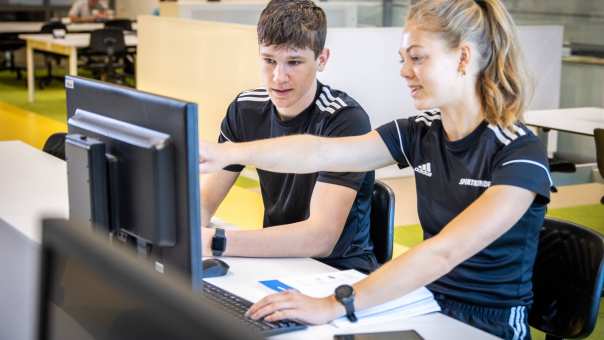 sportkunde liggende foto studenten in studieruimte achter pc computer hugo en carlijn geeft uitleg 2022
