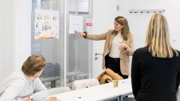 Vrouw gebruikt presentatieblad om naar innovatieve ideeÃ«n te wijzen in klaslokaal 