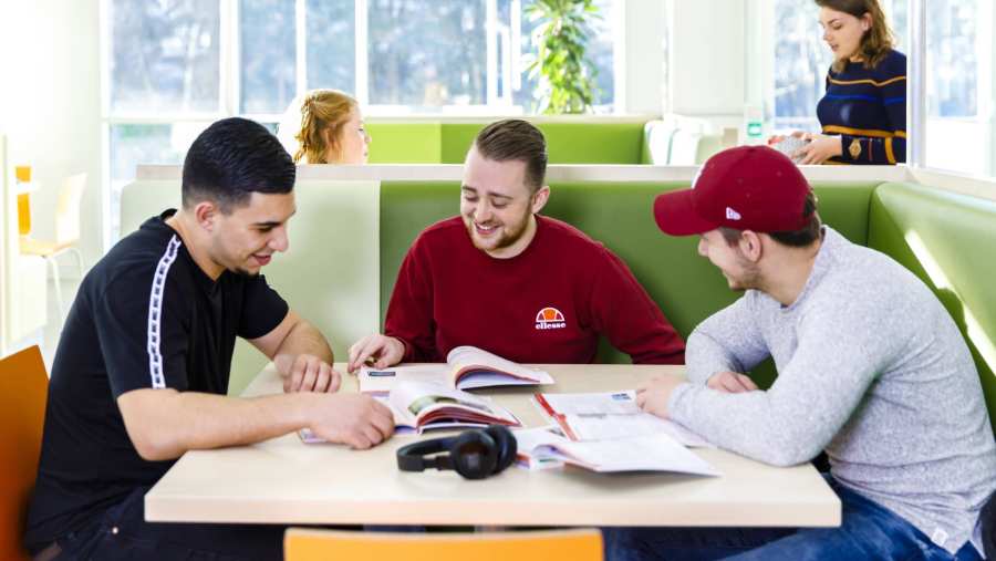 Drie jongens studeren samen in de open werkruimte op de HAN Campus. 