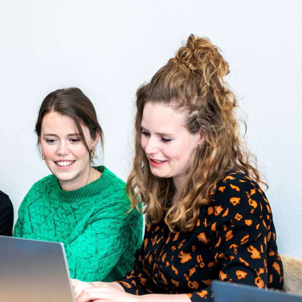 3 studenten tijdens les kijken bij elkaar op laptop