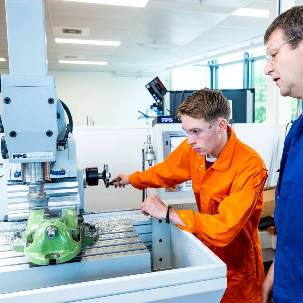 Mechanical Engineering student - Werktuigbouwkunde - with a practical teacher working in the lab