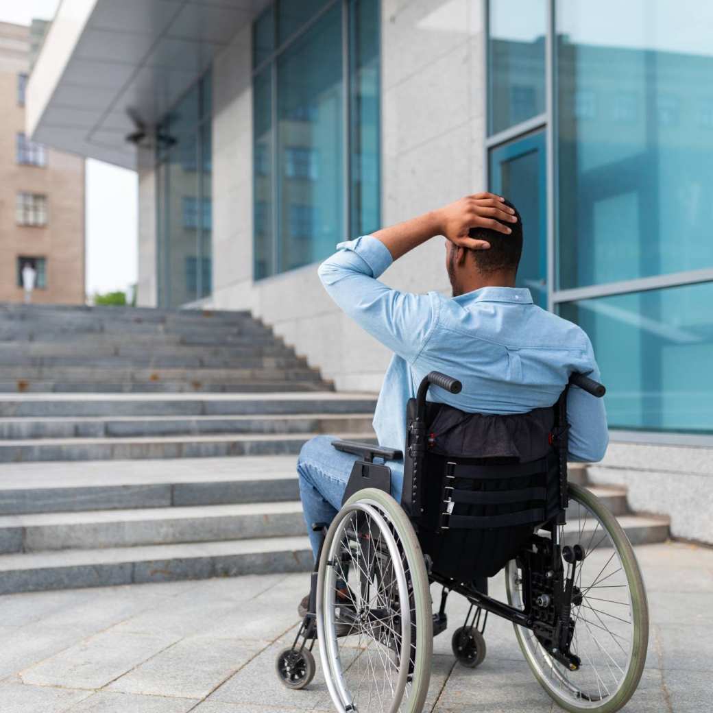rolstoelgebruiker die de trap niet op kan. Inclusie. APS
