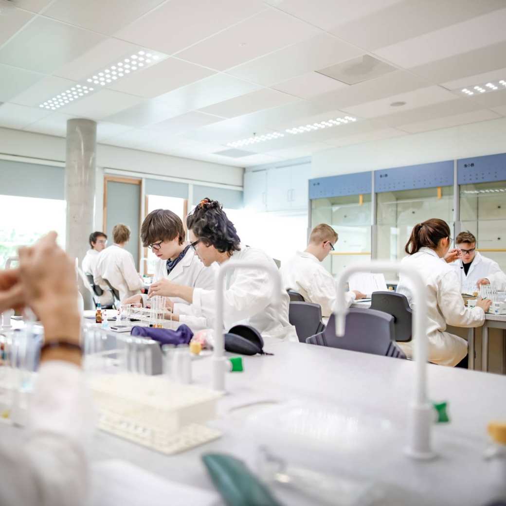 Studenten in labjassen in een Scheikunde laboratorium.