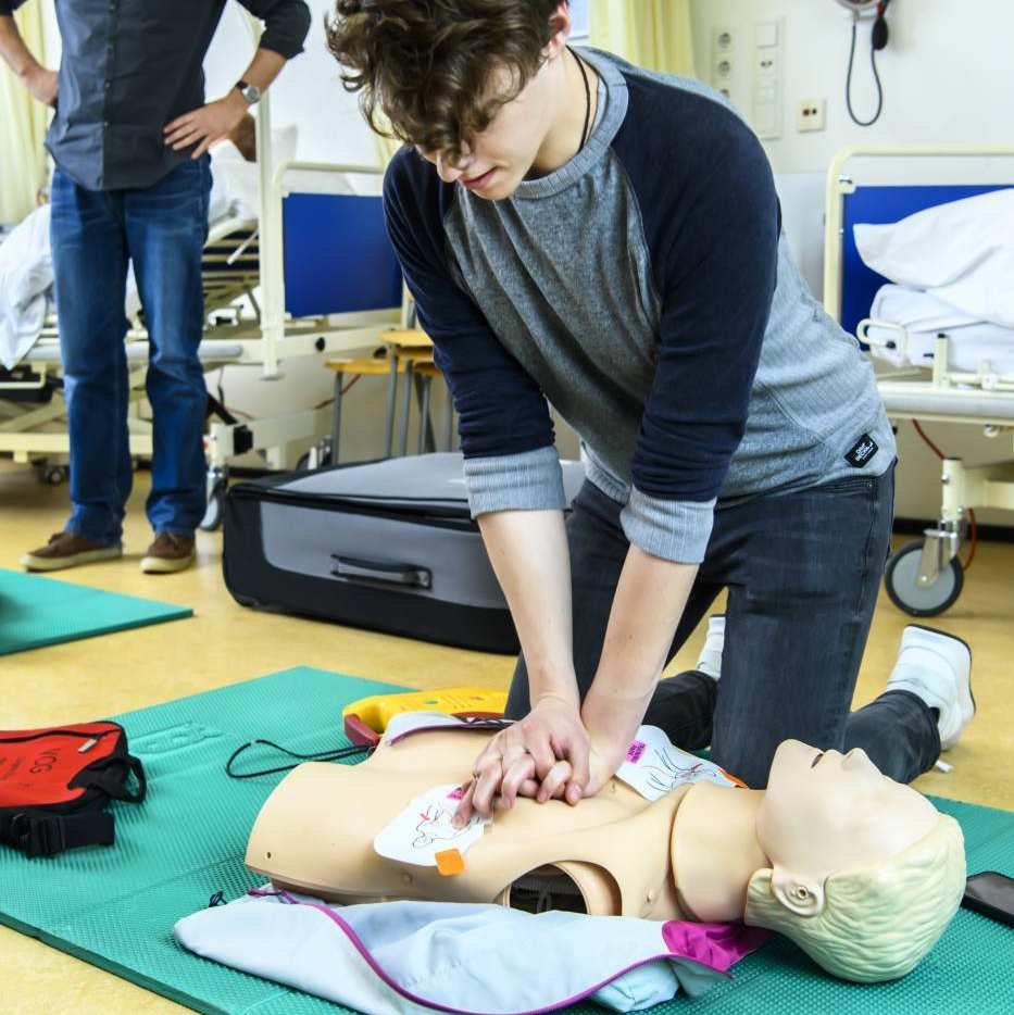 Student Verpleegkunde geeft hartmassage aan een pop in een praktijklokaal