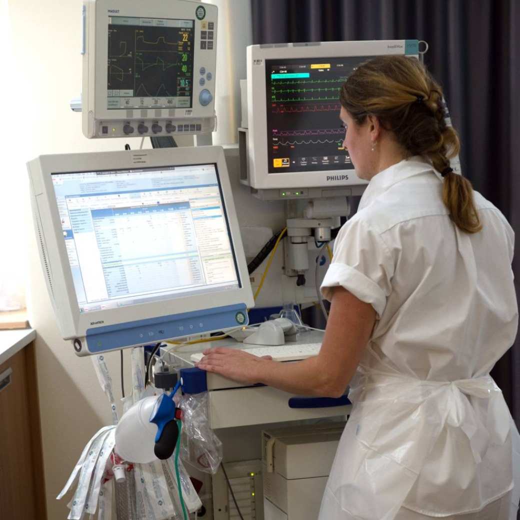 Een intensive care verpleegkundige is bezig met de digitale administratie van haar patient