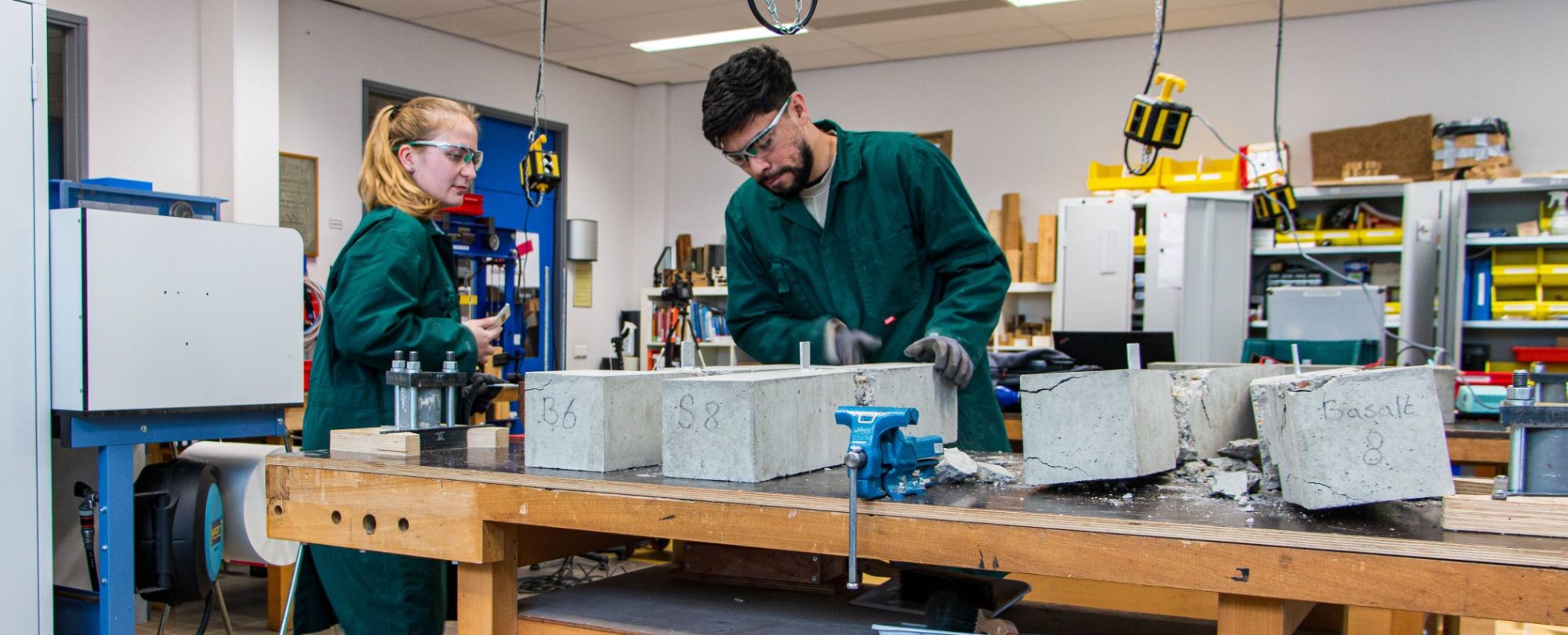 517828 studenten testen in het materialenlaboratorium de sterkte van beton