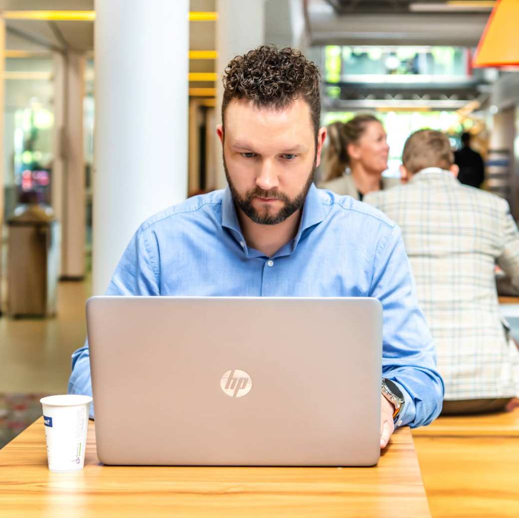Sales professional aan het werk op laptop voor deeltijd master Business Sales