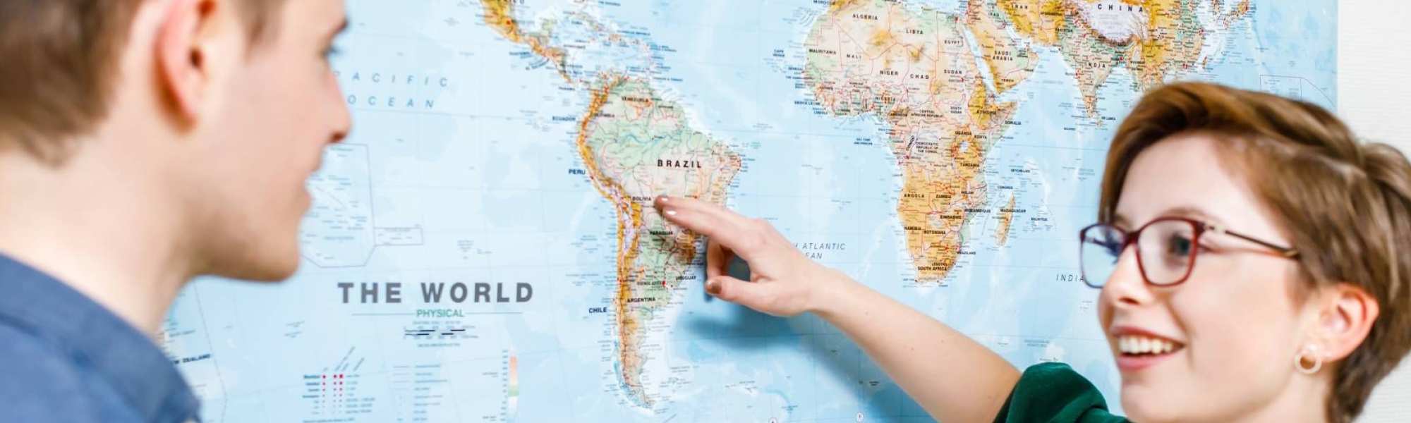 student wijst op wereldkaart
