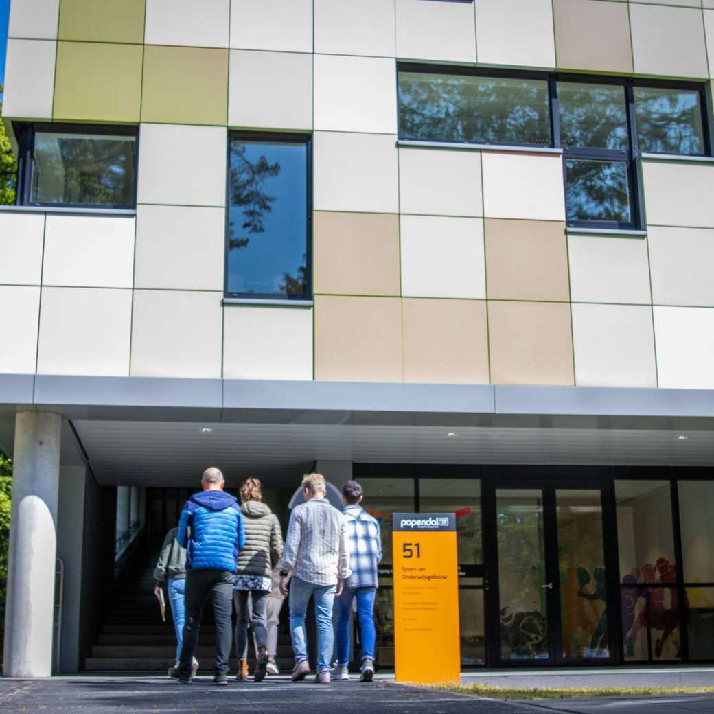 535559 studenten lopen gebouw papendal in