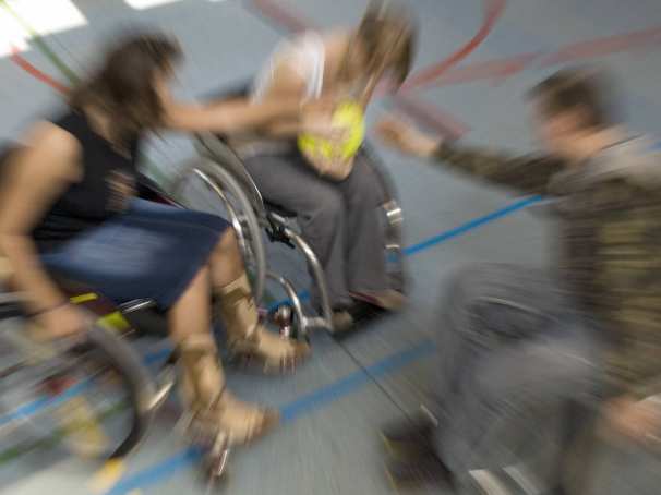 mindervalide jongeren spelen rolstoelbasketbal in de gymzaal van hun tehuis