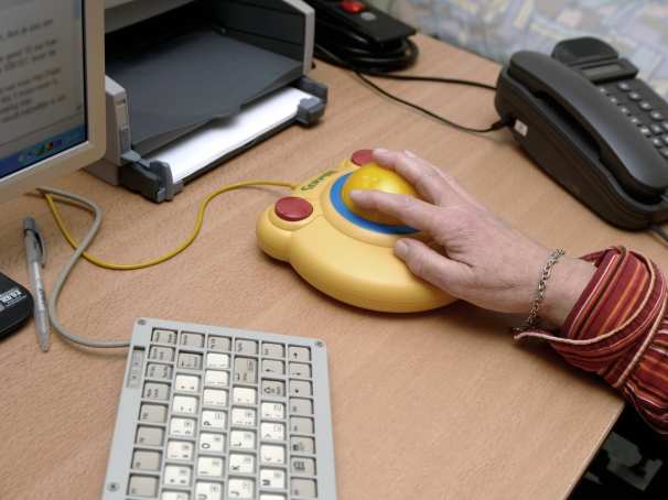 102263 een ernstig spastische patiente werkt achter haar computer met behulp van aangepast toetsenbord en muis