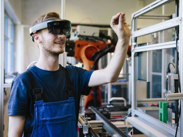 387445 Man / student werkt met AR bril op. Virtual reality in een productieomgeving. 