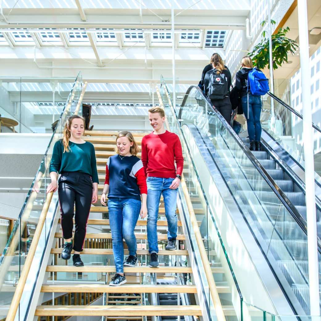 Drie studenten lopen al kletsend de trap af in het I/O gebouw op de HAN campus in Nijmegen.