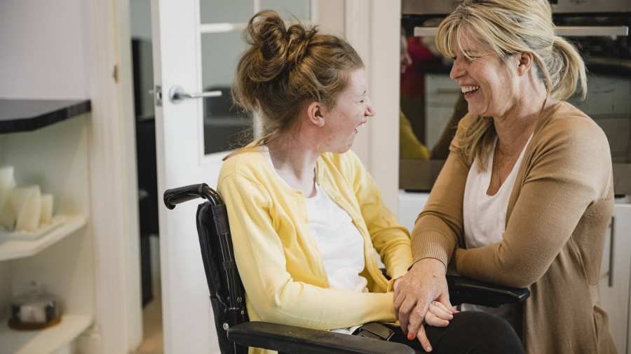moeder en gehandicapte dochter in rolstoel in keuken