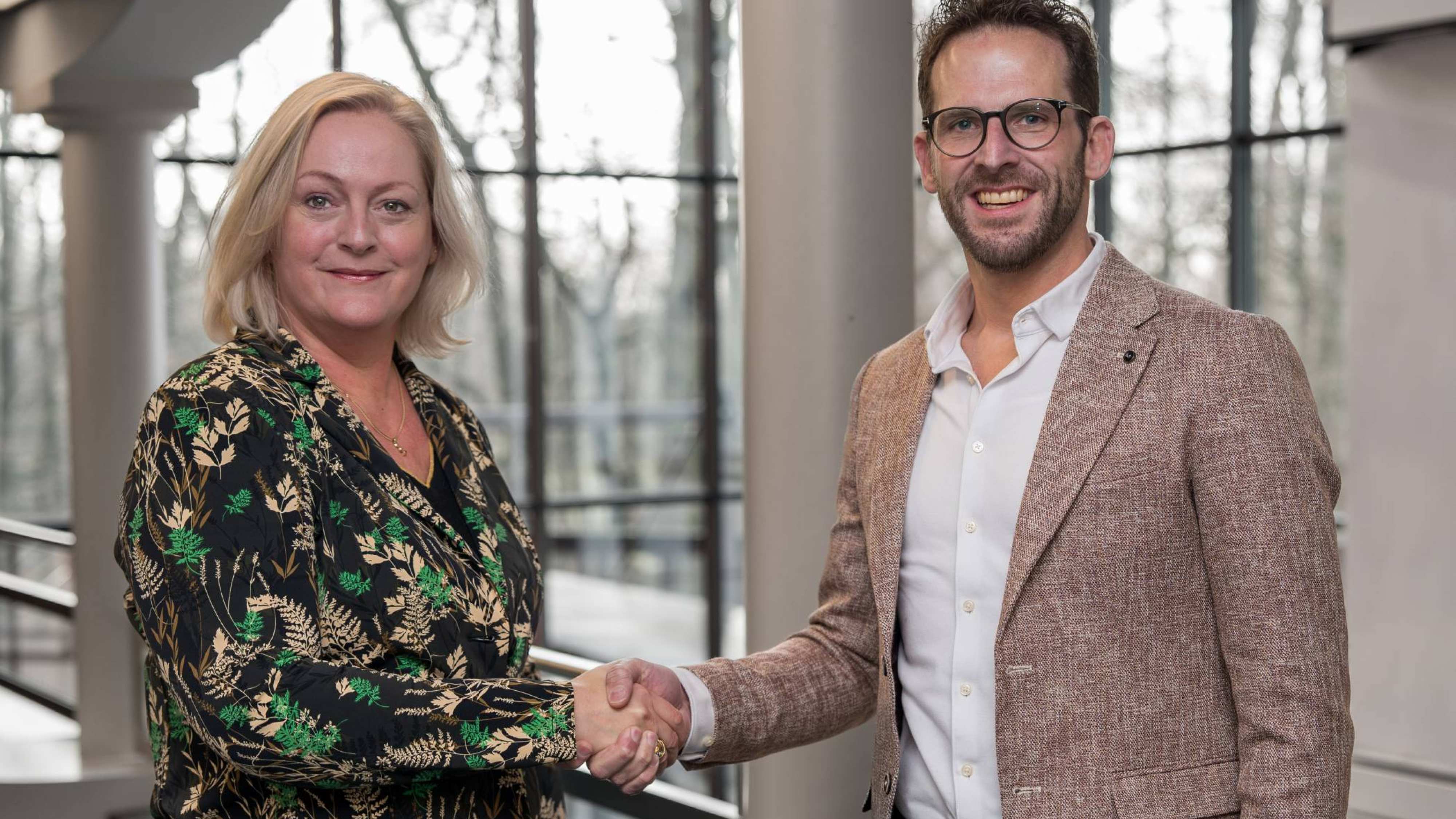 Petra van Halteren van de HAN en Bart Stolk van Business School Nederland schudden elkaar de hand