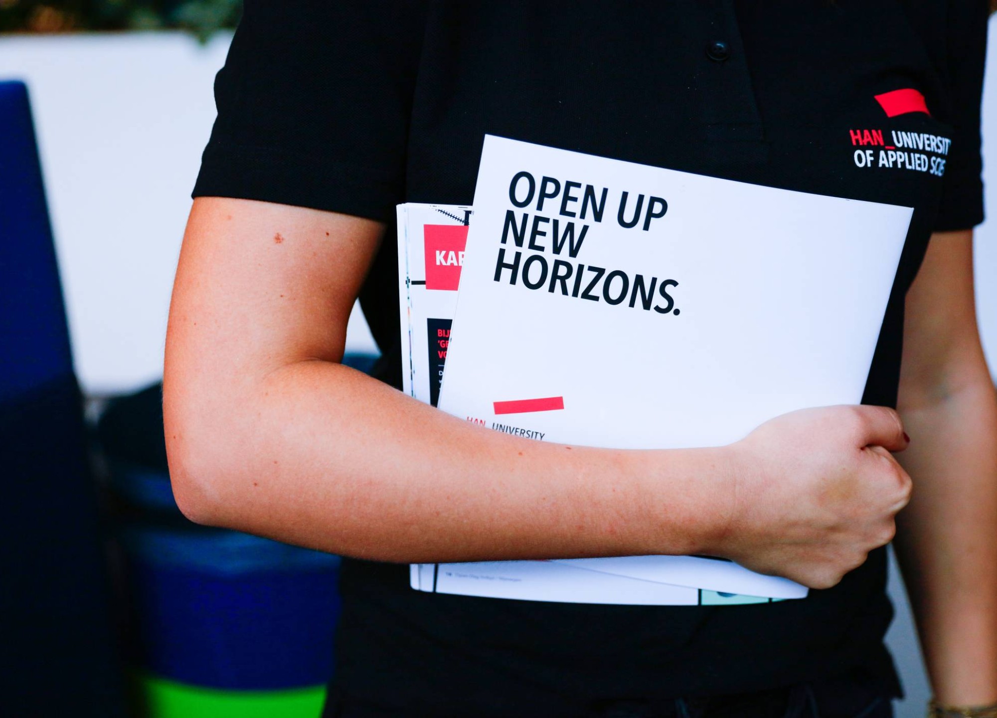 Student houdt flyers onder de arm tijdens de open dag HAN