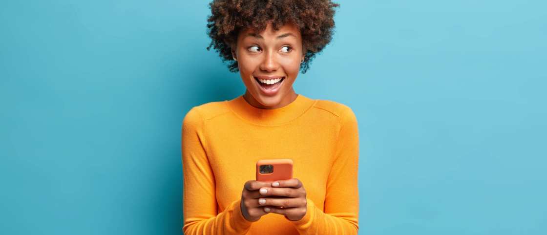 339305 Jonge vrouw gebruikt smartphone terwijl ze lacht