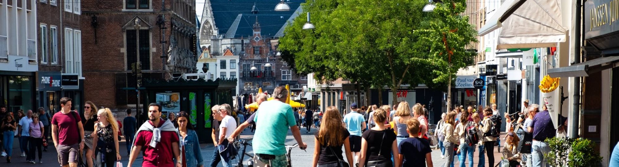 Nijmegen mensen in winkelstraat met kerk op achtergrond