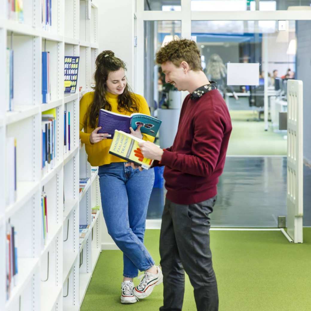 31699 Twee studenten Pedagogiek lezen boek bibliotheek