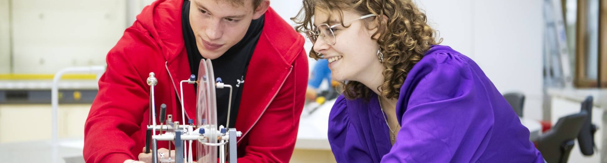 Twee studenten Leraar Natuurkunde kijken aandachtig naar hun experiment.