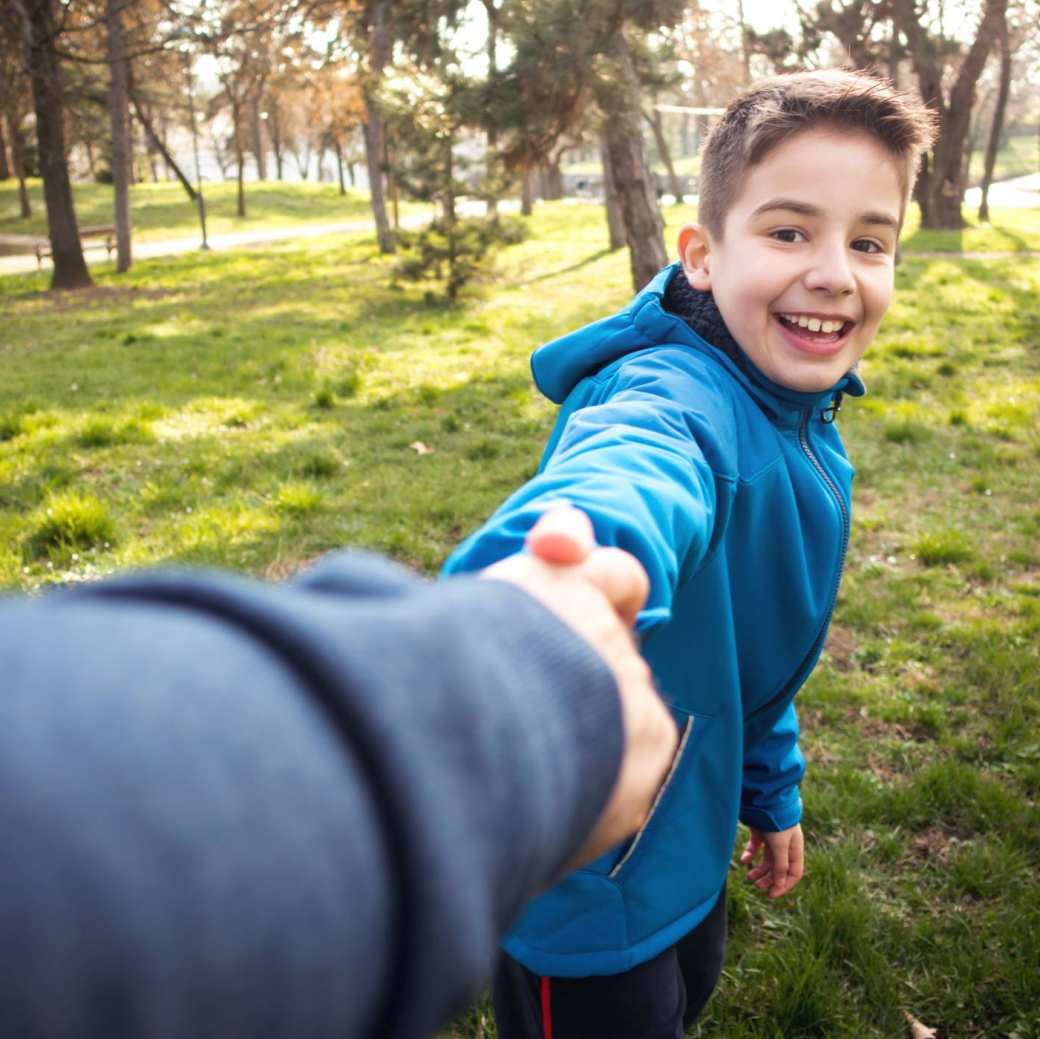 237752 jongen in park die hand van ouder vasthoudt