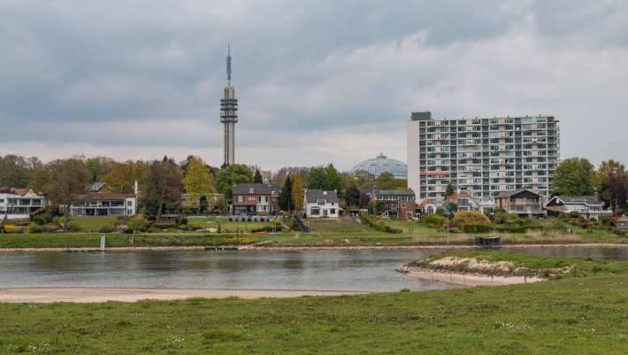 535767 Rijnoever met skyline van Arnhem West met de de Tennettoren de Koepelgevangenis en de Rijnoeverflat Hulkestein