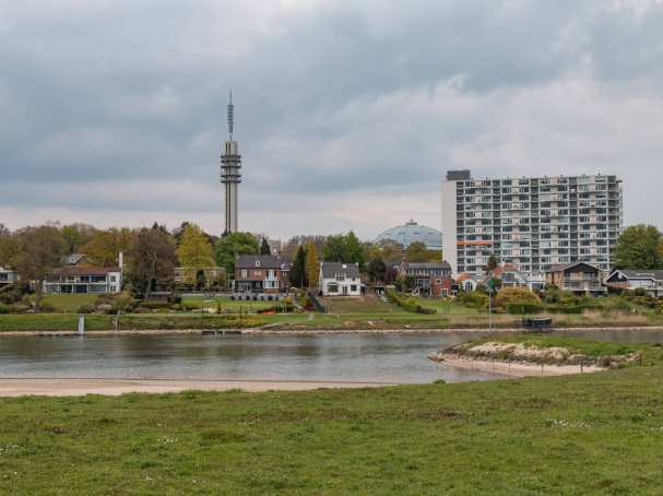535767 Rijnoever met skyline van Arnhem West met de de Tennettoren de Koepelgevangenis en de Rijnoeverflat Hulkestein