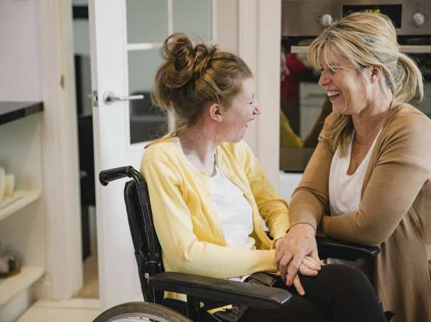 moeder en gehandicapte dochter in rolstoel in keuken