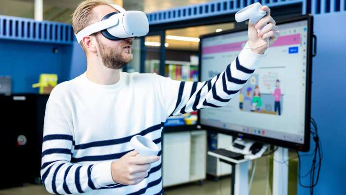 Jongen met VR-bril, doet simulatie laaggeletterdheid