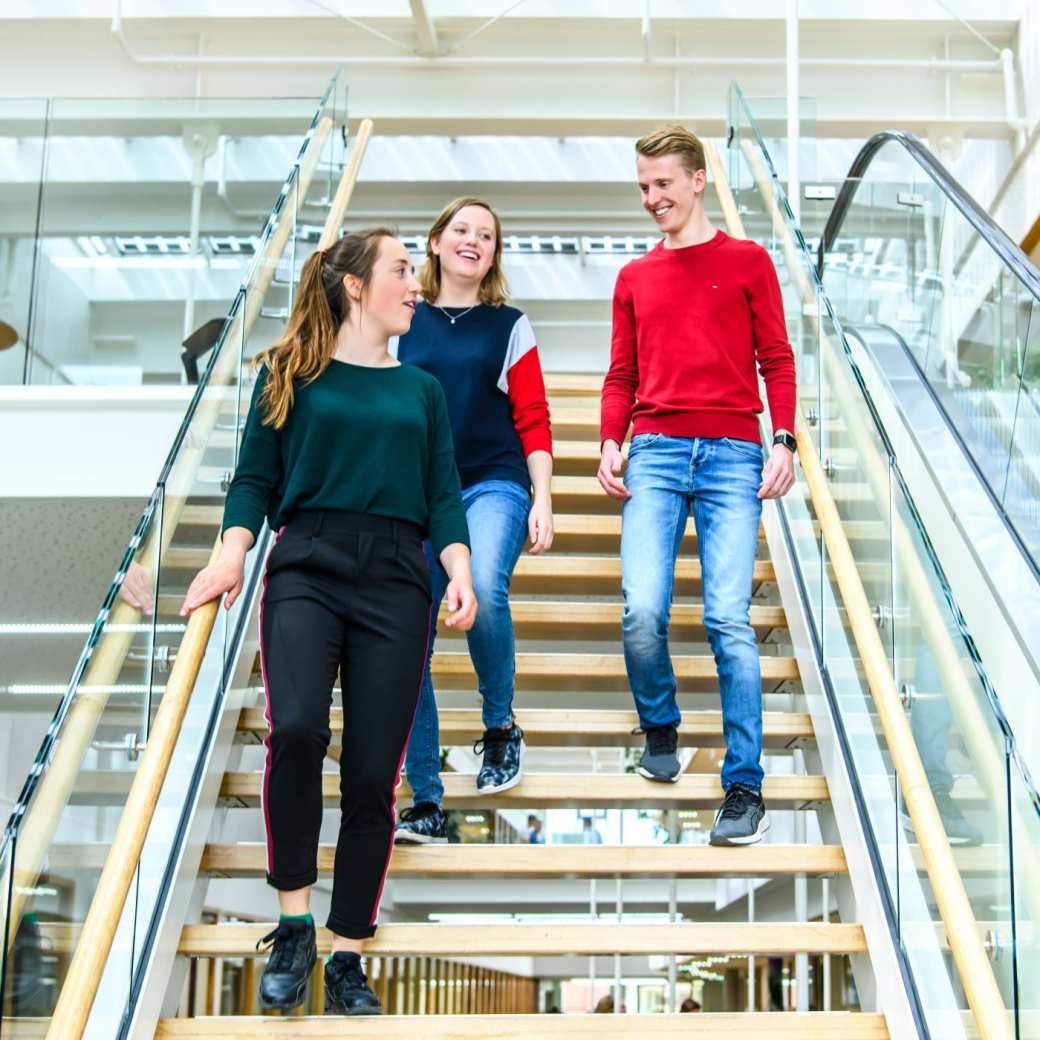 Drie studenten lopen de trap af in het I/O gebouw op de HAN campus in Nijmegen.
