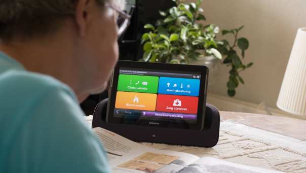 102275 oudere dame gebruikt een tablet met een woningcommunicatiesysteem waardoor ze langer zelfstandig kan blijven wonen
