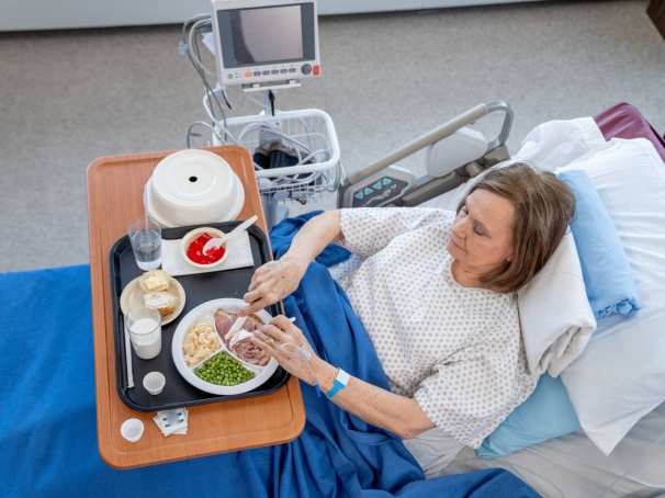 Patient met eten en drinken aan het bed in het ziekenhuis