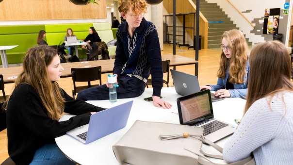 259554 Alpo studenten in overleg aan ronde tafel met hun laptop