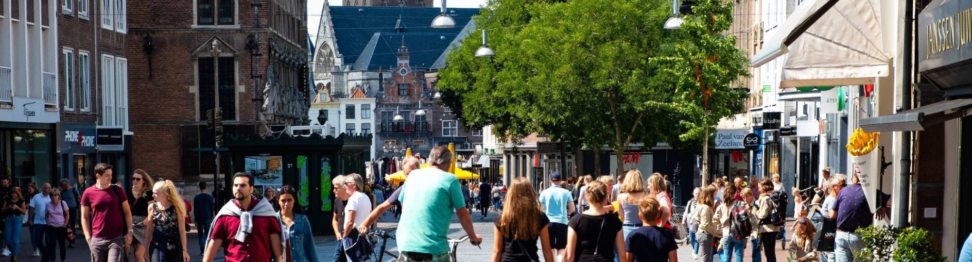 Nijmegen mensen in winkelstraat met kerk op achtergrond
