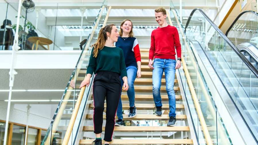 Drie studenten lopen de trap af in het I/O gebouw op de HAN campus in Nijmegen. 
