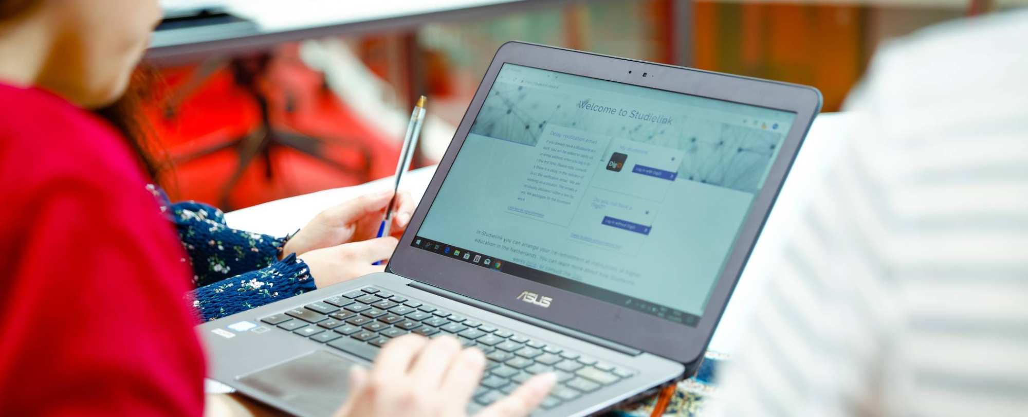 Student houdt laptop vast met Studielink pagina