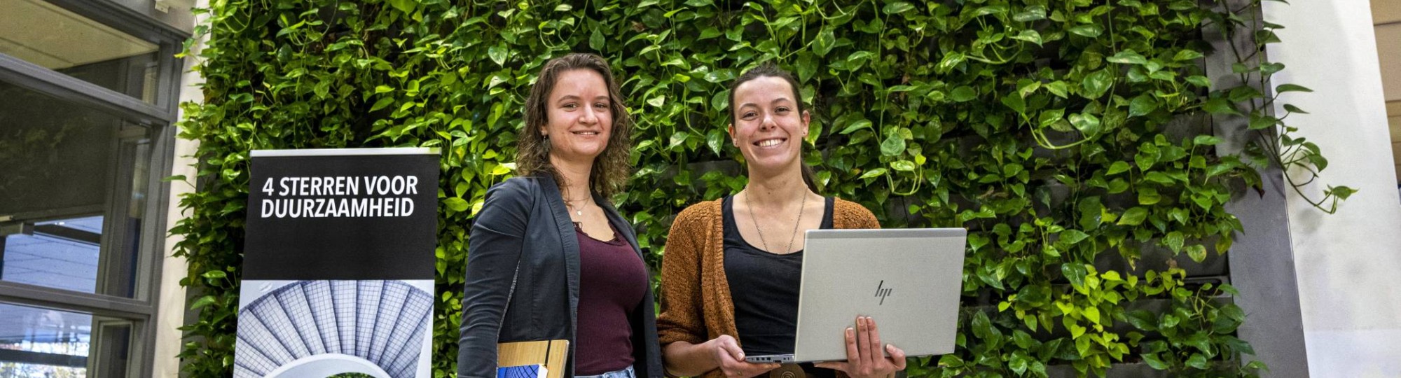 Afstudeerders Fiona Verbrugge (l) en Maaike Diks voor de inpandige groene wand bij HAN Bouwkunde