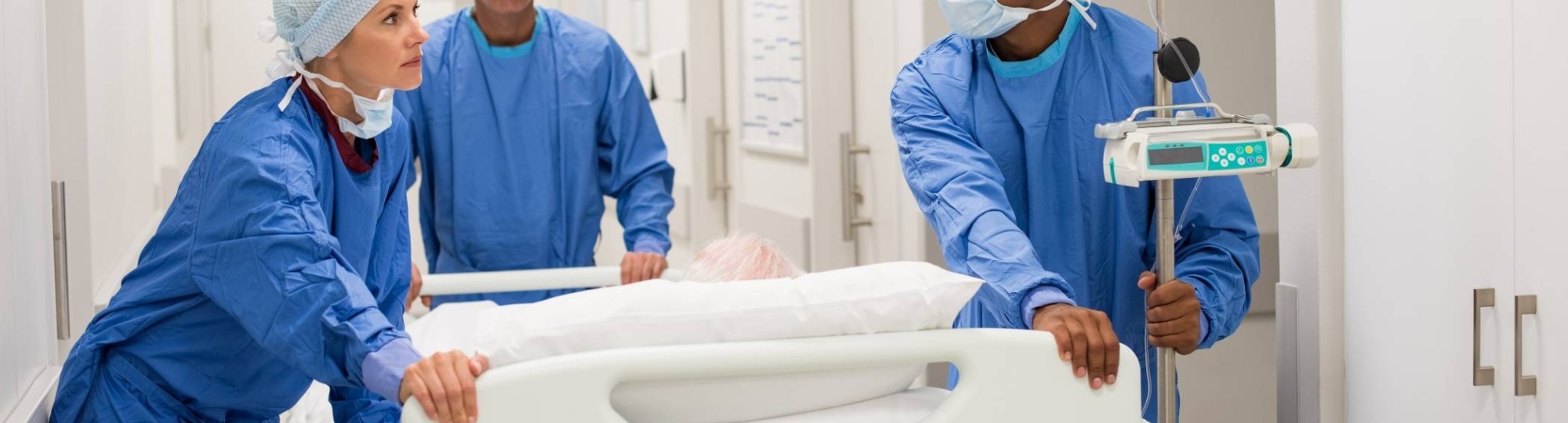 347057 Ziekenhuispersoneel in ziekenhuis duwen een bed met patient