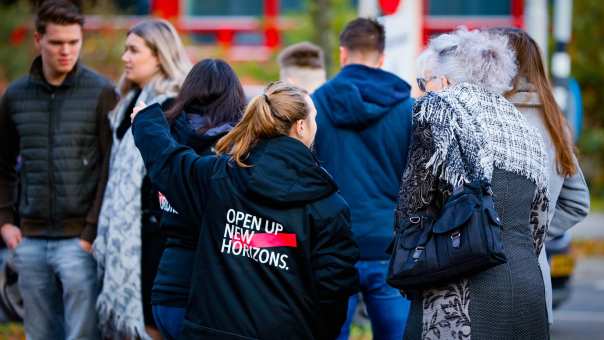 131699 Studente wijst bezoekers van de Open Dag Nijmegen de weg
