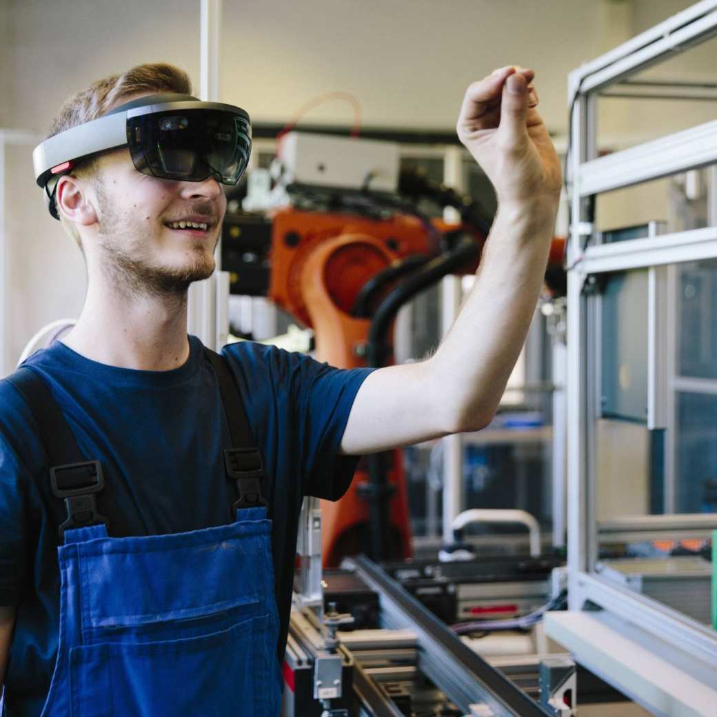 387445 Man / student werkt met AR bril op. Virtual reality in een productieomgeving. 